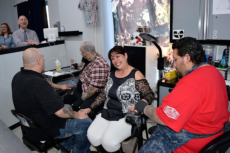 In this April 20, 2018 photo, from left, groom Rich Ziemer, tattoo artist Gabriel Rocha, bride Amber Ziemer and House of Lexx Tattoo and Piercings owner and tattoo artist Alex Valadez gather for a wedding in Beloit, Wis. Officiant Steve Meyer, above left, married the Ziemers at the tattoo shop. Although Meyer said he had officiated more than 4,000 weddings, it was his first ceremony in a tattoo shop. (Hillary Gavan/The Beloit Daily News via AP)