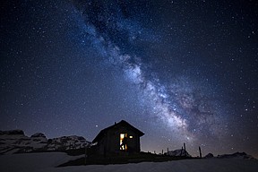 A man gazes at the starry sky in the Milky Way early Friday morning at a little cabin at the Ormont Valley, Switzerland. 