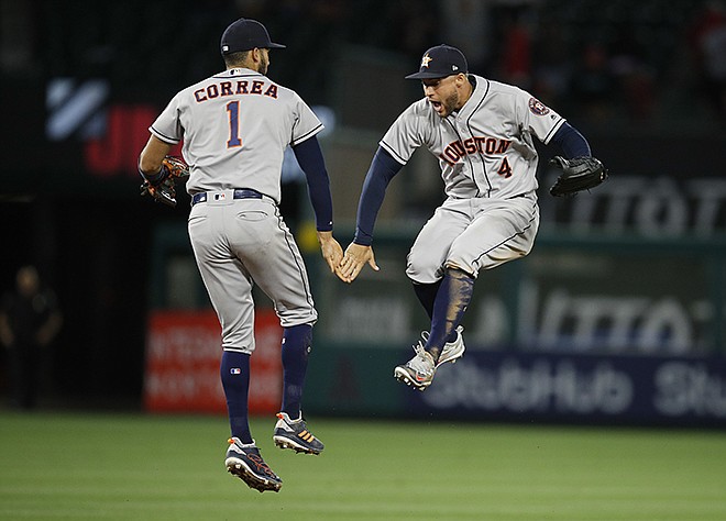 Houston Astros' Carlos Correa, left, and George Springer celebrate the team's 2-0 win over the Los Angeles Angels in a baseball game Wednesday, May 16, 2018, in Anaheim, Calif. 