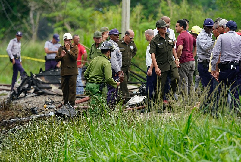 Rescue and search workers investigate the site where a Cuban airliner with 110 passengers on board plummeted into a yuca field just after takeoff from the international airport Friday in Havana, Cuba.