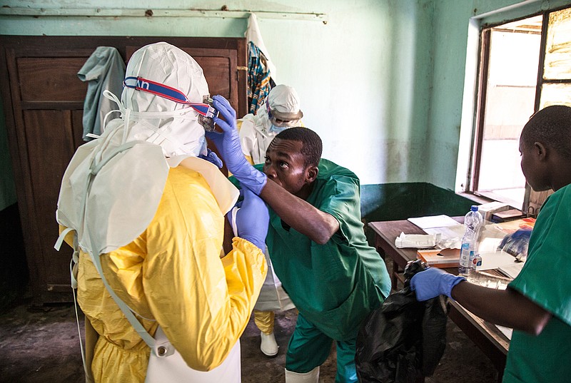 In this photo taken May 12, health workers don protective clothing as they prepare to attend to patients in the isolation ward to diagnose and treat suspected Ebola patients at Bikoro Hospital in Bikoro, the rural area where the Ebola outbreak was announced last week, in Congo.