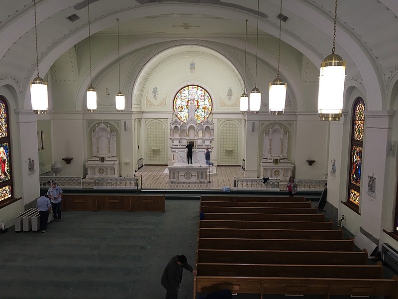 Parishioners work Thursday to remove pews in the sanctuary of St. Edward Catholic Church  so restoration of the space can begin. (Submitted photo)