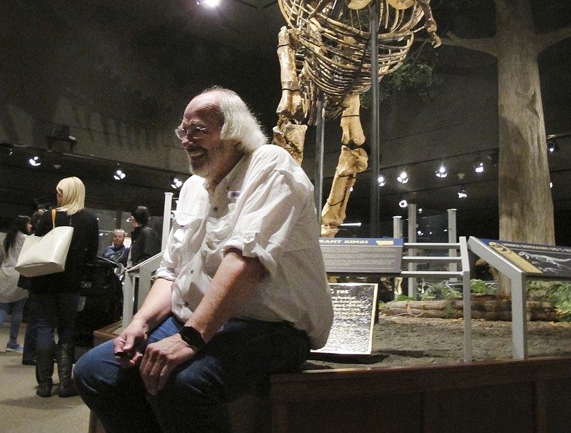 FILE - In this May 21, 2016, file photo, Jack Horner sits under Montana's T-Rex in the Museum of the Rockies in Bozeman, Mont. The Montana paleontologist, Horner, who consulted with director Steven Spielberg on the “Jurassic Park” movies is developing a three-dimensional hologram exhibit that will showcase the latest theories on what dinosaurs looked like. Horner and entertainment company Base Hologram are aiming to have multiple traveling exhibits ready to launch in spring 2018. (AP Photo/Matt Volz, File)