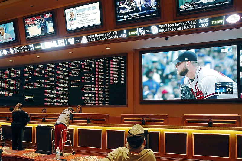 In this Monday, May 14, 2018 file photo, people make bets in the sports book area of the South Point Hotel and Casino in Las Vegas. Those who deal with compulsive gambling are worried that a rapid expansion of sports betting in the U.S. could cause more people to develop gambling problems. The U.S. Supreme Court on Monday cleared the way for states to legalize sports betting. (AP Photo/John Locher, File)
