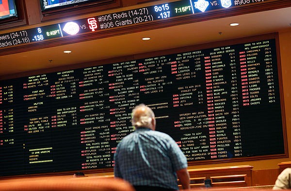 In this May 14 file photo, betting odds are displayed on a board in the sports book at the South Point hotel and casino in Las Vegas. A new poll finds that half of Americans approve of legal sports betting. The Fairleigh Dickinson University poll conducted shortly before the U.S. Supreme Court cleared the way for states to legalize sports betting found that 50 percent of Americans favor it, with 37 percent opposed.