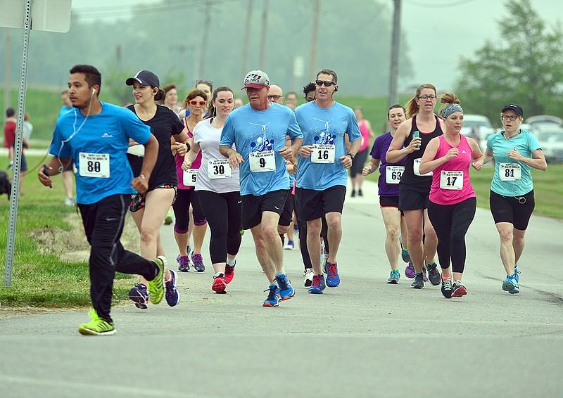 Runners and walkers race Saturday during the Happy Feet for Healthy Minds 5K run/Walk at North Jefferson City Recreation Area.