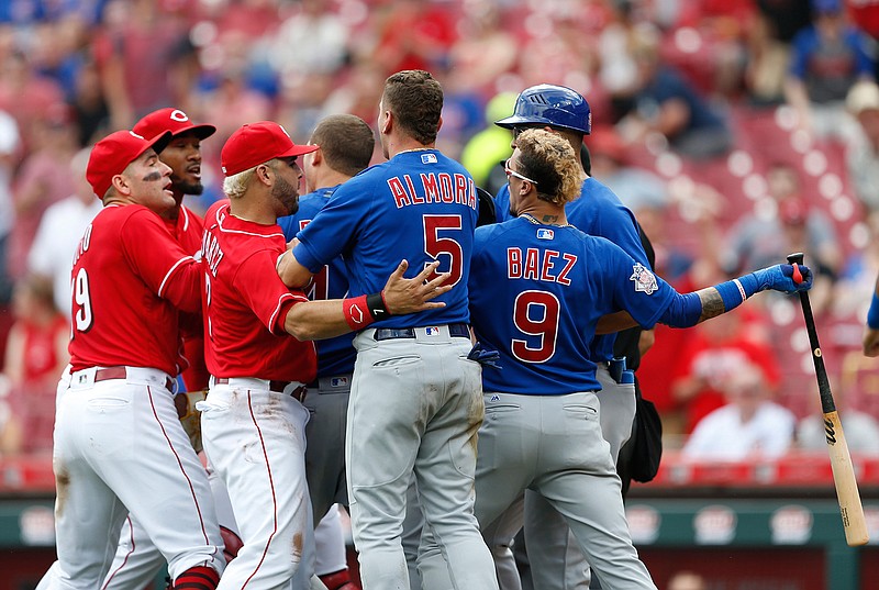 Chicago Cubs' Javier Baez, right, has a few words for Cincinnati Reds relief pitcher Amir Garrett, second from left, after striking out during the seventh inning in the first baseball game of a doubleheader, Saturday, May 19, 2018, in Cincinnati. (AP Photo/Gary Landers)