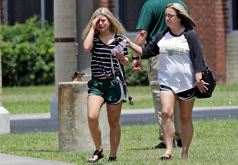 A student, left, reacts after retrieving her belongings inside Santa Fe High School in Santa Fe, Texas, on Saturday, May 19, 2018. Students and teachers were allowed to return to parts of the school to gather their belongings. A gunman opened fire inside the school Friday, May 18, killing several people. (AP Photo/David J. Phillip)