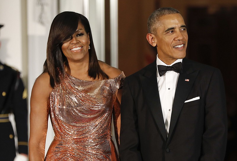 FILE - In this Oct. 8, 2016 file photo, President Barack Obama and first lady Michelle Obama wait to greet Italian Prime Minister Matteo Renzi and his wife Agnese Landini for a State Dinner at the White House in Washington. Netflix says that it has reached a deal with Barack and Michelle Obama to produce material for the streaming service. Netflix said Monday, May 21, 2018, in a tweet, that the former president and first lady will produce films and series for the service, potentially including scripted and unscripted series, documentaries and features. (AP Photo/Pablo Martinez Monsivais, File)