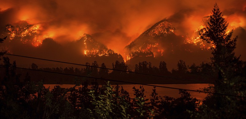 FILE - This Sept. 4, 2017, file photo provided by KATU-TV shows a wildfire as seen from near Stevenson, Wash., across the Columbia River, burning in the Columbia River Gorge above Cascade Locks, Ore. A teenager who started the major wildfire in the scenic Columbia River Gorge in Oregon has been ordered to pay restitution for at least the next decade, though it's unlikely the boy will ever cover his nearly $37 million bill. (Tristan Fortsch/KATU-TV via AP, File)