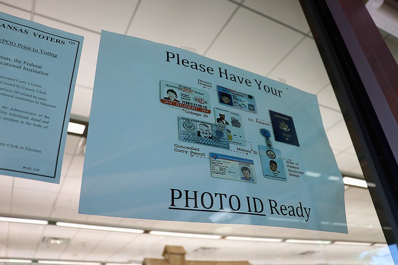 A sign is posted above the check-in station for an early voting precinct May 7 at the Roosevelt Thompson Library in Little Rock. The sign warns voters that they will be asked to show an identification card. (Associated Press)