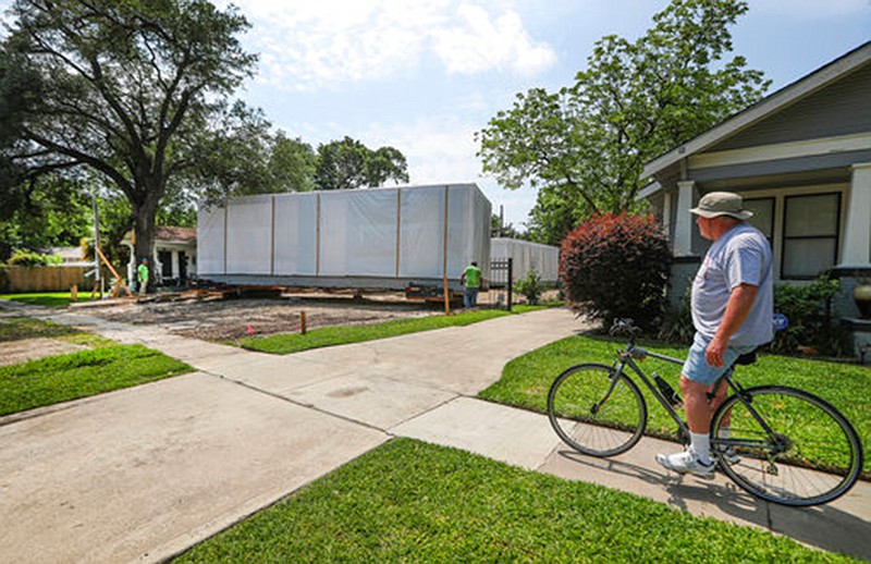 Steve Heiney watches workers move one of the sections of Wayne Braun's new modular house May 2, 2018, in Houston's Heights neighborhood. The Houston Chronicle reported that in about four months, these so-called modules—framed concrete slabs made in a warehouse in Navasota—will have been transformed into a 3,000-square-foot, architect-designed house clad in glass, siding and masonry blocks centered around a courtyard. (Steve Gonzales/Houston Chronicle via AP)