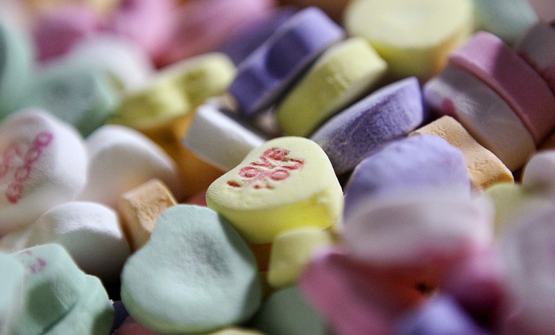 FILE - In this Jan. 14, 2009 file photo, colored "Sweethearts" candy is held in bulk prior to packaging at the New England Confectionery Company in Revere, Mass. Four bidders are vying to buy the bankrupt manufacturer of Necco Wafers, Sweethearts and other iconic candies. A bankruptcy auction is scheduled for Wednesday, May 23, 2018. (AP Photo/Charles Krupa, File)