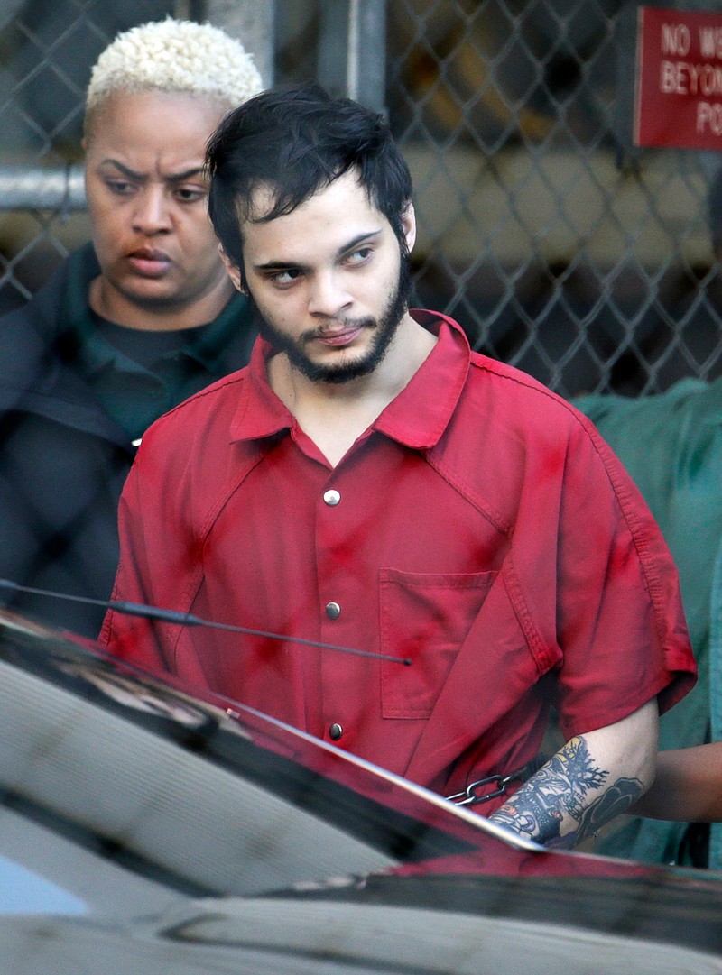 FILE- In this Jan. 30, 2017 file photo Esteban Santiago is escorted from the Broward County jail for an arraignment in federal court in Fort Lauderdale, Fla. Santiago pleaded guilty in exchange for a life prison sentence in the January 2017 Florida airport shooting that killed five people and wounded six. (AP Photo/Lynne Sladky, File)