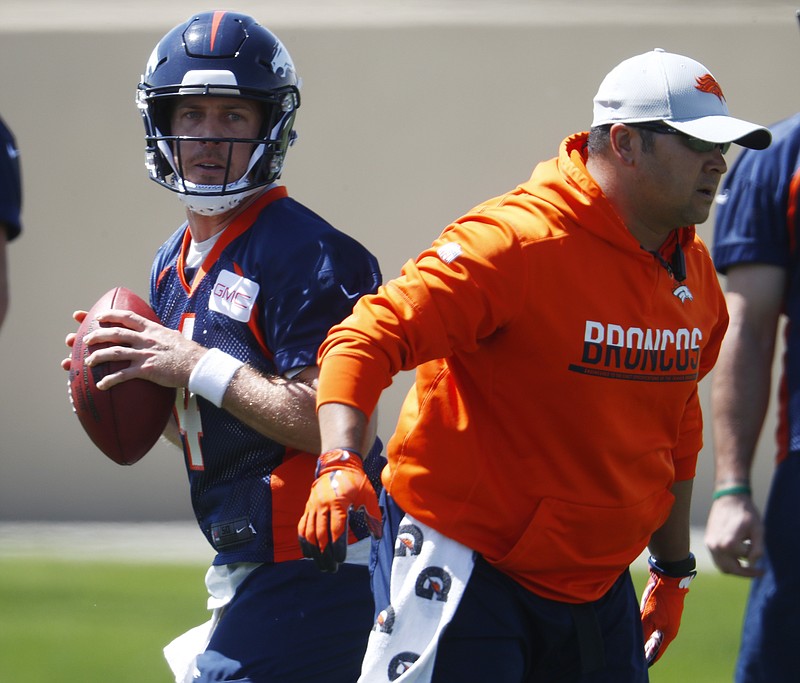Denver Broncos quarterback Case Keenum, back, takes part in a drill during an NFL football minicamp session Tuesday, May 22, 2018, at the team's headquarters in Englewood, Colo.(AP Photo/David Zalubowski)
