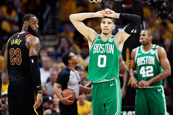 As LeBron James of the Cavaliers looks on, Jayson Tatum of the Celtics reacts after being called for a foul during Monday night's game in Cleveland. The Cavaliers defeated the Celtics 111-102 to even the Eastern Conference finals at 2 games each.