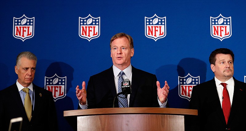 NFL Commissioner Roger Goodell, center, is flanked by Pittsburgh Steelers president Art Rooney II, left, and Arizona Cardinals owner Michael Bidwill during a news conference Wednesday in Atlanta. Goodell announced that NFL team owners have reached an agreement on a new league policy that requires players to stand for the national anthem or remain in the locker room. (Associated Press)