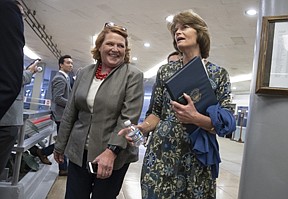 Sen. Heidi Heitkamp, D-N.D., left, and Sen. Lisa Murkowski, R-Alaska, arrive to vote on a bill to expand private care for military veterans as an alternative to the troubled Veterans Affairs health system, on Capitol Hill in Washington, Wednesday, May 23, 2018. 