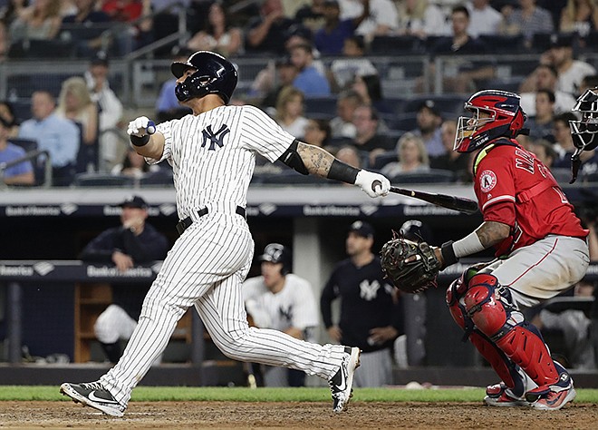 Los Angeles Angels catcher Martin Maldonado watches as New York Yankees' Gleyber Torres, left, follows through on a home run during the seventh inning of a baseball game Friday, May 25, 2018, in New York. 