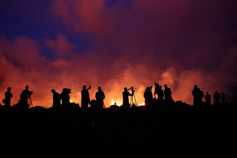 Residents and members of the media are silhouetted Thursday, May 24, 2018, as active lava fissures near what is now the end of Leilani Street continue to spew forth lava at Leilani Estates near Pahoa, Hawaii. (Associated Pre George F. Lee/Honolulu Star-Advertiser via AP)