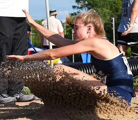 Anna Vollet of Helias splashes in the sand during the Class 4 girls long jump Friday in the state championships at Adkins Stadium.