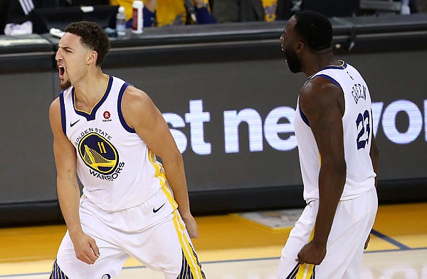 Warriors guard Klay Thompson (left) celebrates with forward Draymond Green during the second half of Game 6 of the Western Conference Finals against the Rockets on Saturday in Oakland, Calif.