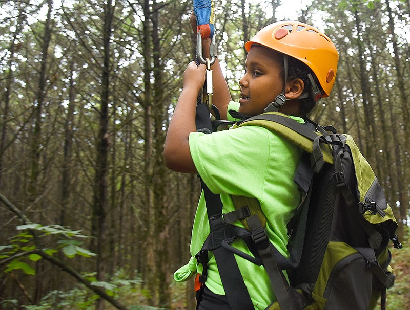 Elijah Moore, 7, ziplines Saturday through the confidence course as a part of Camp MAGIC at Binder Park.