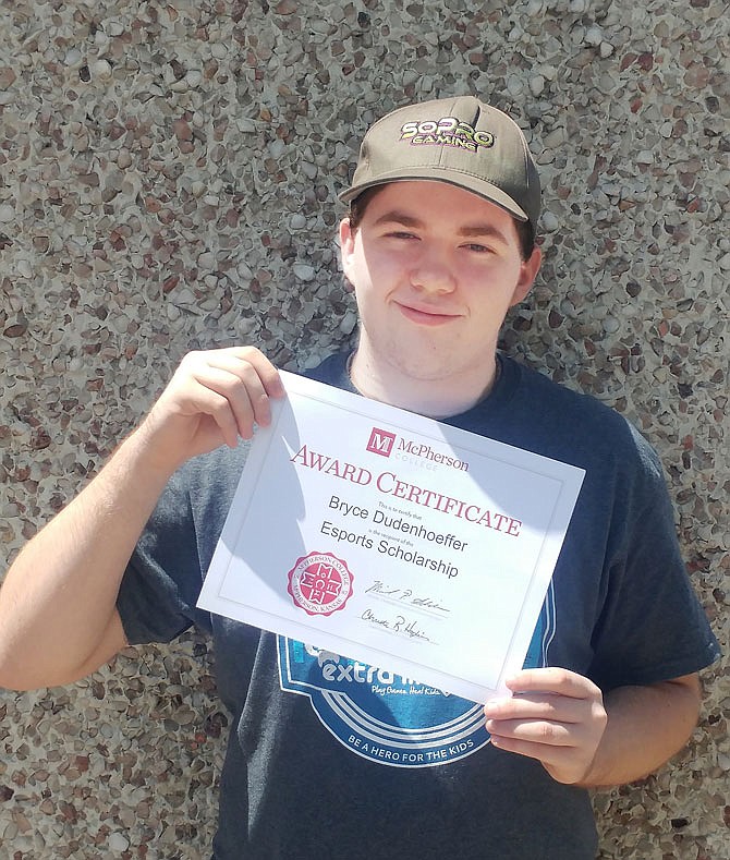 Recent Helias Catholic High School graduate Bryce Dudenhoeffer holds up his e-sports Scholarship to McPherson College where he'll play on the e-sports team.