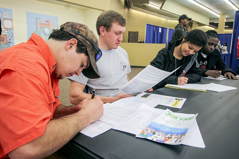 FILE- In this Feb. 8, 2018, file photo, Garrett Thornton, left, Bradley Harper, Heather Wood and Marcus Brown fill out various job applications at the Governor's Job Fair in the Tommy E. Dulaney Center in Meridian, Miss. On Tuesday, June 5, the Labor Department reports on job openings and labor turnover for April. (Paula Merritt/The Meridian Star via AP, File)