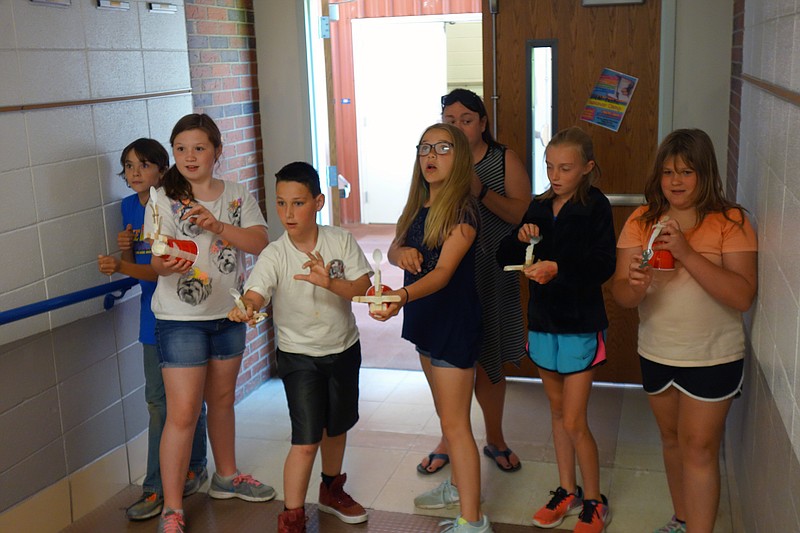 Cole R-1 teacher Samantha Yarnell instructs her fifth-grade students Levi Templeton, Claire Eickhoff, Chase Wilburs, K'Lea Basnett, Matayah Steinman-Bush and Anna Eickhoff to fire their catapults May 30, 2018, at the Russellville STEM-tastic Summer Camp.