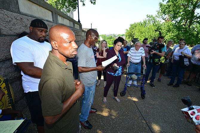 Marcellus Williams II, son of death row inmate Marcellus Williams, far left, listens as death row exonerees Reggie Griffin, foreground, and Joseph Amrine speak Tuesday during a rally supporting Marcellus Williams in front of the Missouri Supreme Court. The NAACP is asking Gov. Mike Parson to keep Williams from being executed for the 1998 killing of a former St. Louis Post Dispatch reporter.