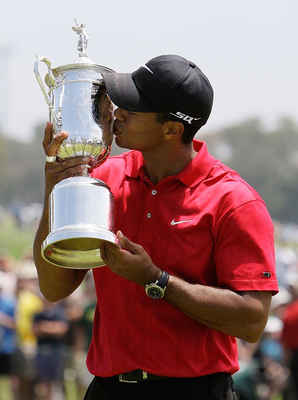 In this June 18, 2008 file photo, Tiger Woods kisses his U.S. Open championship trophy after winning a sudden-death playoff against Rocco Mediate at Torrey Pines in San Diego. 