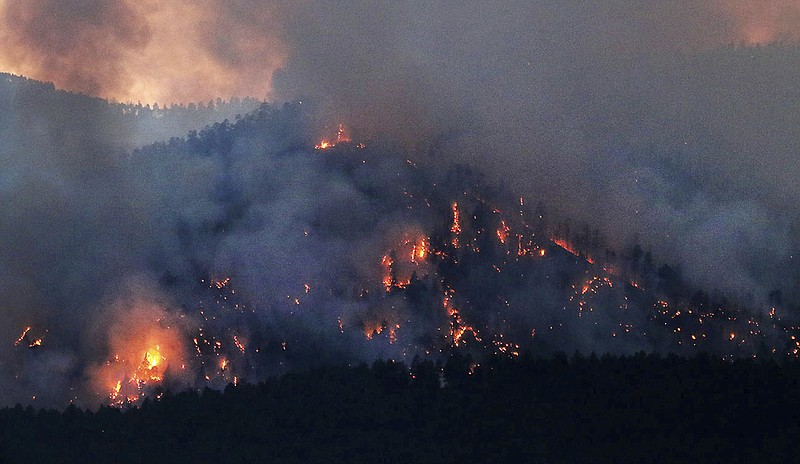 In this Tuesday, June 12, 2018, photograph, hot spots glow after sunset near the Falls Creek Subdivision as the 416 Fire burns near Durango, Colo. (Jerry McBride/The Durango Herald via AP)