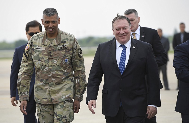 U.S. Secretary of State Mike Pompeo, right, walks with U.S. General Vincent K. Brooks, left, commander of United States Forces Korea, upon his arrival at Osan Air Base in Pyeongtaek Wednesday, June 13, 2018.  South Korea's presidential office said Pompeo will meet President Moon Jae-in Thursday morning to discuss the meeting, which made history as the first between sitting leaders of the U.S. and North Korea. (Jung Yeon-je/Pool Photo via AP)