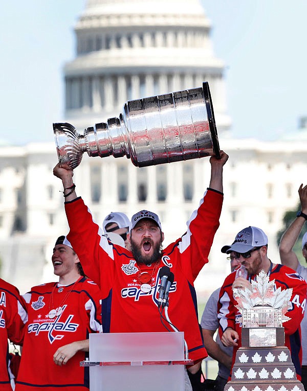 Alex Ovechkin of the Capitals holds up the Stanley Cup trophy during Tuesday's championship celebration at the National Mall in Washington.