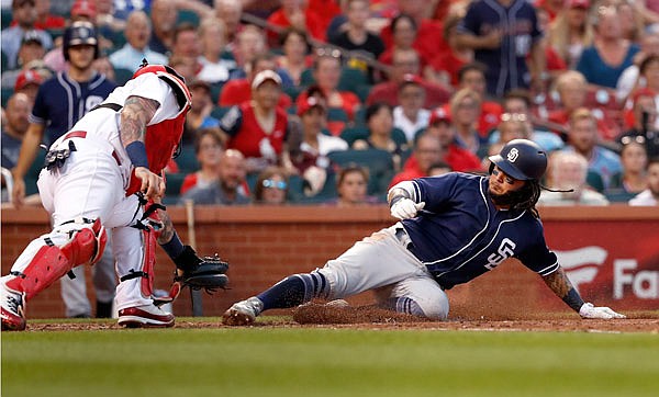 Freddy Galvis of the Padres scores under of the tag from Cardinals catcher Yadier Molina during the fourth inning of Tuesday night's game at Busch Stadium in St. Louis.