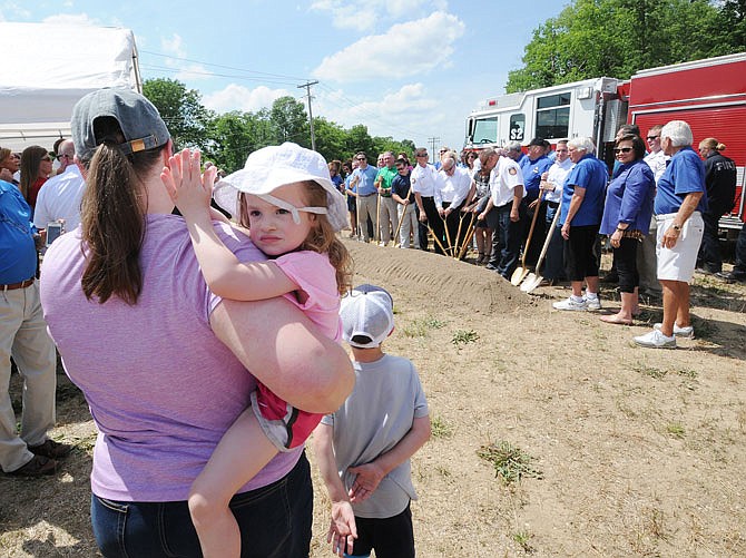 Lisa Powell and Heather, 3, watch the Jefferson City Fire Department conduct its groundbreaking ceremony Wednesday for the new Fire Station No. 2 site at 3025 Robinson Drive.