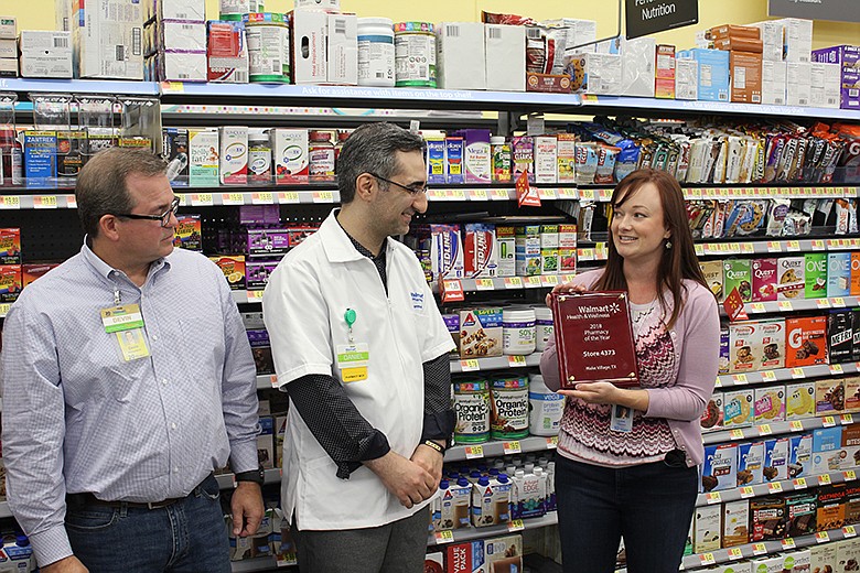On Friday, June 15, 2018, Walmart executives Devin Richardson, left, and Lisa Thornton, right, present the chain's 2018 Small-format Pharmacy of the Year award to Daniel Nejadi, manager of the pharmacy at Wake Village's Walmart Neighborhood Market. The pharmacy topped 710 others at Walmart's stores smaller than supercenters. Criteria included sales growth and customer satisfaction.