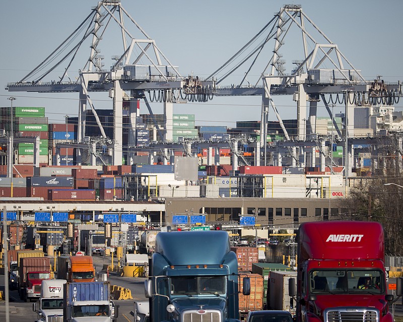 FILE- In this Jan. 30, 2018, file photo, tractor-trailer trucks move cargo in shipping containers out of the Port of Savannah in Savannah, Ga. President Donald Trump announced Friday, June 15, 2018, that starting next month the U.S. will impose a 25 percent tariff on up to $50 billion in Chinese imports. (AP Photo/Stephen B. Morton, File)