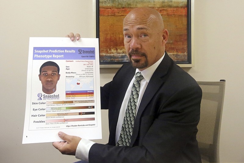 Private investigator Jason Jensen holds a phenotype report at his office Friday, June 15, 2018, in Salt Lake City. Groups of private investigators in Utah and California have been emboldened by the arrest of the suspected Golden State Killer and are spearheading a push to replicate authorities' use of DNA evidence in that case by urging amateur genealogists to contribute genetic information to a public DNA database, despite concerns about privacy.  (AP Photo/Rick Bowmer)