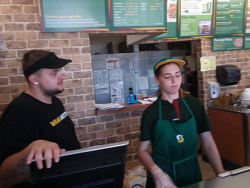 Abbie Mulder and Harley Sartain, sandwich makers at the Subway on 4014 N. State Line Ave., serve customers on the last day before closing. This Subway location will be closed as of today, June 16, 2018, though it may reopen later, pending a decision from owners.