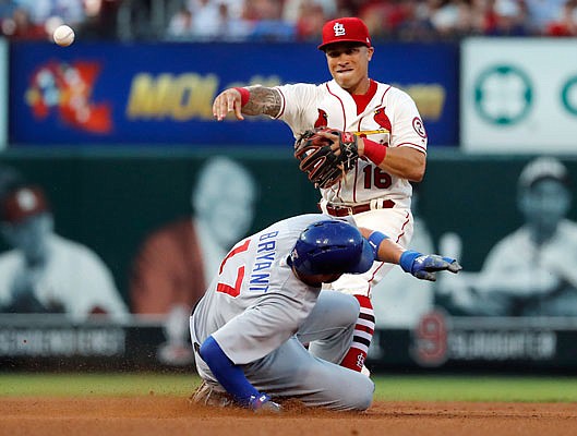 Kris Bryant of the Cubs is out at second as Cardinals second baseman Kolten Wong throws to first during Saturday night's game at Busch Stadium.