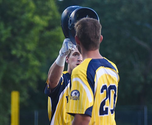 Cole Evans touches helmets with Renegades teammate Austin Blazevic after hitting a solo home run during Saturday night's game against the Sedalia Bombers at Vivion Field.