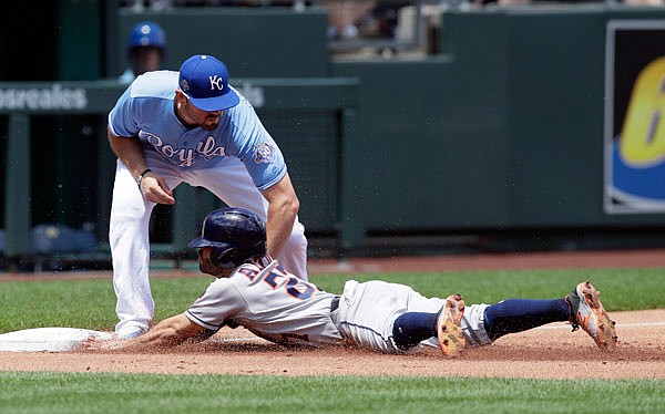 Jose Altuve of the Astros is tagged out while trying to advance on a sacrifice fly by Royals third baseman Mike Moustakas during the first inning of Saturday's game at Kauffman Stadium.