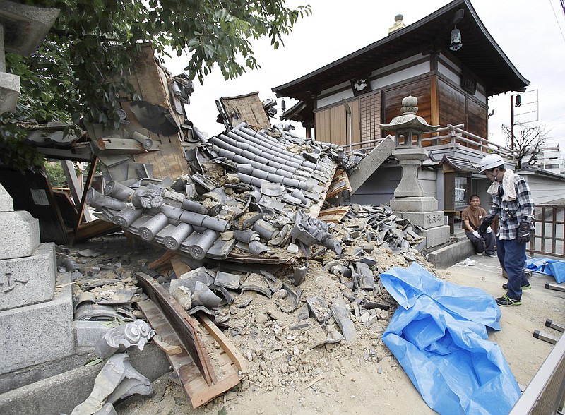 The gate of Myotoku-ji temple collapses after an earthquake hit Ibaraki City, Osaka, western Japan, Monday, June 18, 2018. A strong earthquake knocked over walls and set off scattered fires around metropolitan Osaka on Monday morning. (Yosuke Mizuno/Kyodo News via AP)