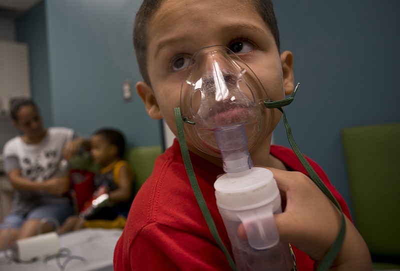 In this May 29, 2018 photo, Yahir Garcia receives one of his two daily treatments for asthma at a medical center in San Juan, Puerto Rico. Garcia is one of many that doctors say are struggling to breathe asthma cases in the U.S. territory spike in the aftermath of the Category 4 storm, raising concerns about deteriorating health conditions on an island struggling to prepare for a new hurricane season. (AP Photo/Ramon Espinosa)