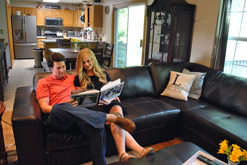 <p>Samantha Pogue/News Tribune</p><p>Above: Kyle and Madison Loethen reminisce as they look at their wedding photo book in the living room of their Ashland home. Viewers nationwide watched the couple’s first house-buying experience on a Thursday episode of HGTV’s popular show, “House Hunters.”</p><p>Left: The Loethens mixed classic heirloom pieces such as Madison’s inherited crystal with modern color tones and decor to create a personalized, stylish space.</p>