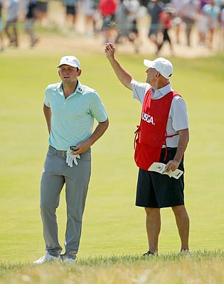 Matt Parziale checks his line to the pin as his father and caddie, Vic Parziale, tests the wind direction during Sunday's final round of the U.S. Open in Southampton, N.Y.