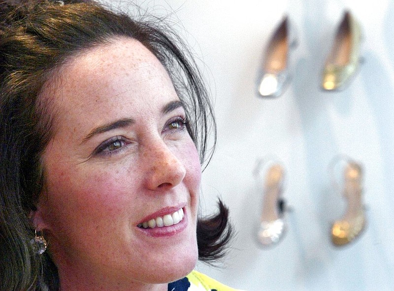 In this May 13, 2004 file photo, the late designer Kate Spade poses with shoes from her next collection in New York. The funeral for Spade will be held on Thursday, June 21, 2018 at Our Lady of Perpetual Help Redemptorist Church in Kansas City, Mo. Spade was found dead by suicide on June 5 in her New York City home.