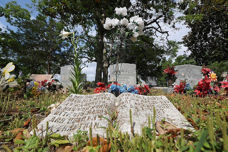 Brightly colored flowers twinkle against the gray headstones on May 1, 2018, in the San Isidro Cemetery, which sits inside a Sugar Creek subdivision in Sugar Land, Texas. The cemetery holds bodies of Hispanic families that worked for the Imperial Sugar Co. in the early 1900s. Family members of the workers continue to get buried there. 